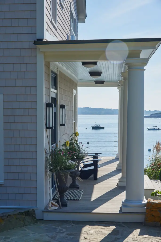 Stone walkway leading to covered porch with adirondak chairs for enjoying the coastal Maine views.